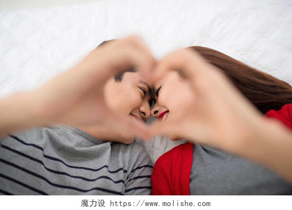 亚洲夫妻恋人躺在床上做爱形状的手幸福情侣幸福的人感动日记情人节